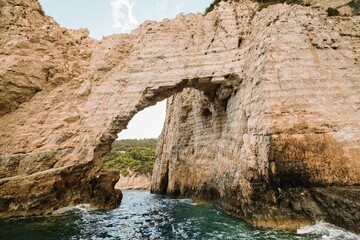 Exploring the breathtaking summer coast of Greece, where unique rock formations stand tall against the vibrant blue sea under a clear sky