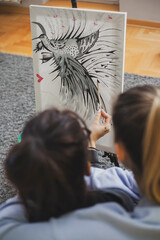 Woman Painting on Canvas with Brushes and colors