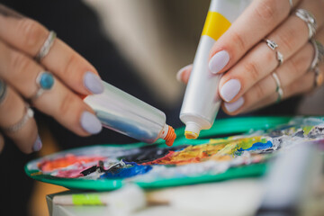 Woman Painting on Canvas with Brushes and Colors