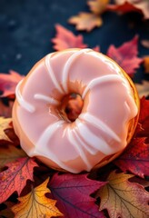 A glazed donut assortment rests on autumn leaves, bakery, october