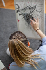 Woman Painting on Canvas with Brushes and colors