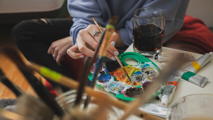 Woman Painting on Canvas with Brushes and colors