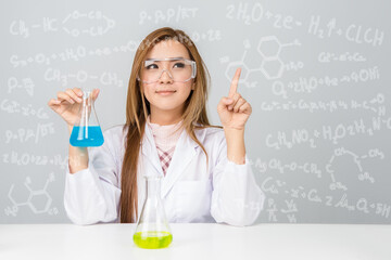 Beautiful Asian scientific researcher holding a liquid solution with science or chemistry formula..