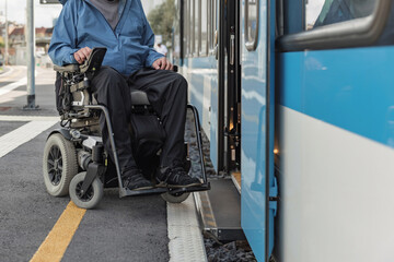 Man with disability on electric wheelchair entering a train. Accessible travel and inclusive...