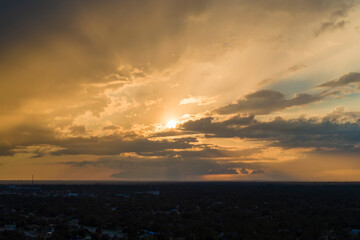 Amazing evening skyscape. Sunset sky with bright colorful clouds over dark landscape