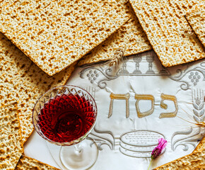 Unleavened bread food - matzoh and glass of red wine for Jewish Passover Holiday. White serviette...