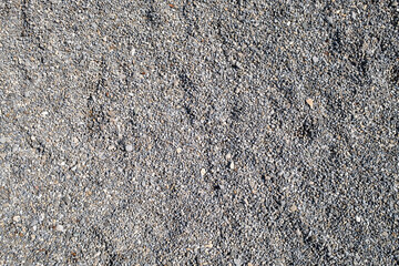 Small Gray Pebbles Forming a Natural Texture on a Gravel Park Path. A close-up of small gray pebbles creates a uniform, textured surface, ideal for backgrounds, landscaping, or construction purposes.