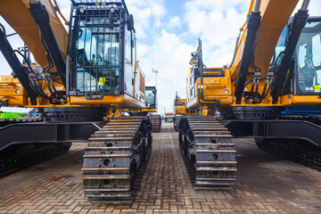 New yellow crawler excavators are parked on the site.