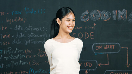 Young student celebrate her successful plan while raise her arm. Happy teenager looking at camera...