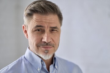 Fototapeta premium Business portrait - confident middle aged businessman smiling. Happy mid adult older man in shirt. Copy space .