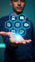 Individual holds a hologram in hand displaying diverse technology icons, illuminated in a bright environment with a modern color scheme, engaging with viewers directly.