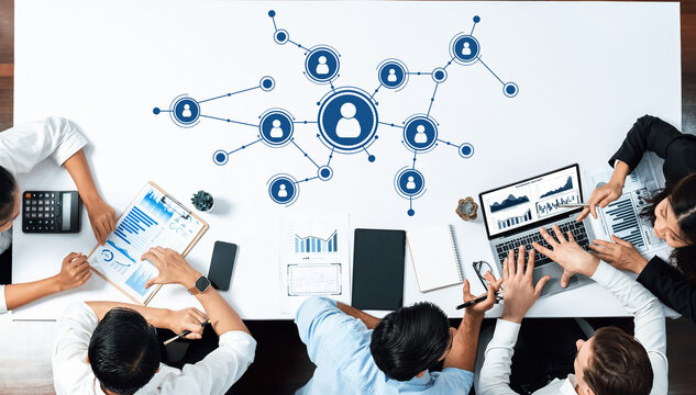 A dynamic office scene featuring a collaborative business meeting focused on data analysis and networking, showcasing diverse professionals engaged in strategic discussions. Amity