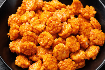Spicy chilli rice crackers in white bowl. Party food snacks