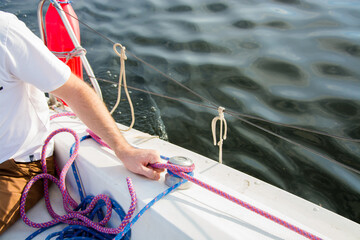 Young sailor holding rope on sailboat