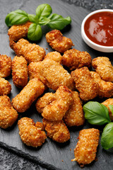 Crispy breaded scampi nuggets with sauce on stone board