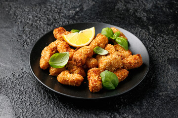 Crispy breaded scampi nuggets with sauce on plate