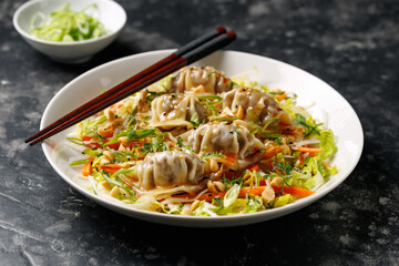 Gyoza Salad or Dumpling Salad with fresh vegetables, nuts and herbs. Asian food