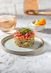 Superfood buckwheat tartare with avocado, capers and red onion, topped with serrano jamon slices