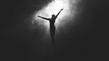 Naklejka premium Silhouette of a person with arms raised against a bright