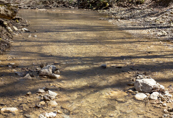 a fragment of a mountain river on a shallow riverbed, the time of the year in nature