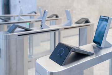turnstile with access control system in modern office building interior.