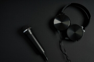 black microphone and headphones on a black background