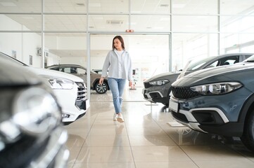 Happy friendly woman customer female buyer client chooses auto wants to buy new automobile