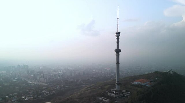 Kok Tobe TV Tower. Mountainous terrain. The view from the drone. Spring time. Clouds and smog.