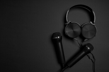 black microphone and headphones on a black background