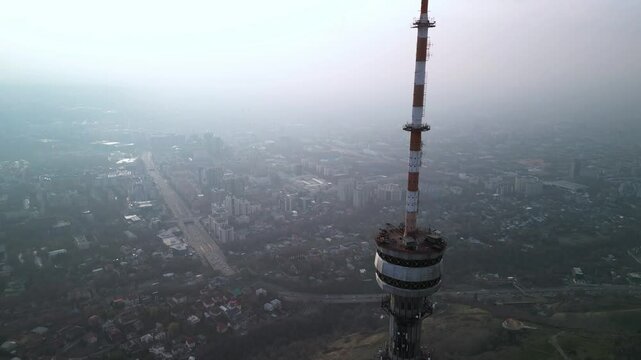 Kok Tobe TV Tower. Mountainous terrain. The view from the drone. Spring time. Clouds and smog.