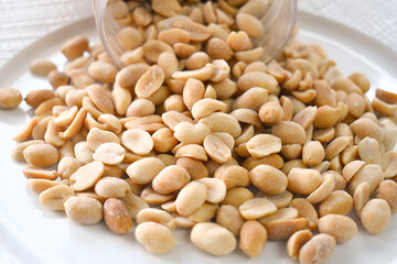 Salted peanuts on a white plate. Healthy and dietary food.