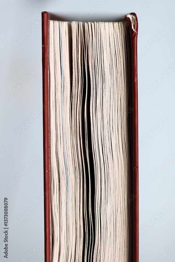 Poster Stack of books on a wooden table with some space around.