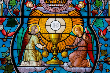 Stained glass (19th century) of Representation of the Eucharist and chalice, symbol of bread and wine surrounded by angels.