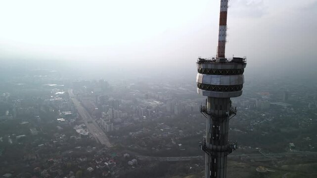 Kok Tobe TV Tower. Mountainous terrain. The view from the drone. Spring time. Clouds and smog.