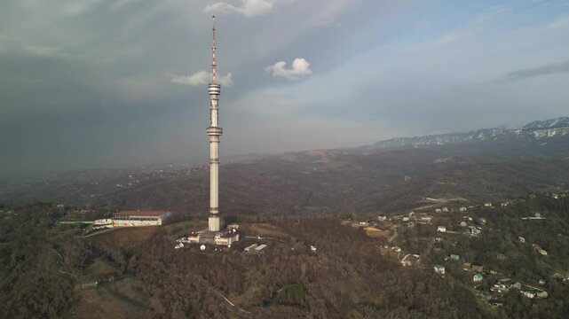 Kok Tobe TV Tower. Mountainous terrain. The view from the drone. Spring time. Clouds and smog.