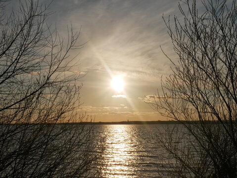 Sonnenuntergang &uuml;ber winterliche Landschaft am See 