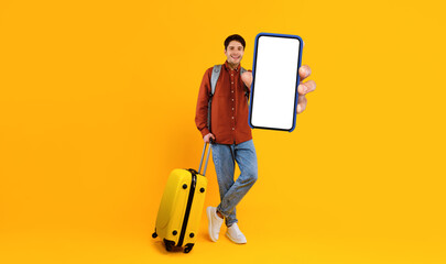 Male Tourist Showing Smartphone Empty Screen Holding Big Phone In Hand Standing With Suitcase...
