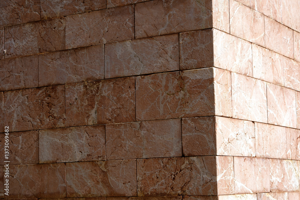 Poster sunlit corner of marble wall architecture with textured stone patterns