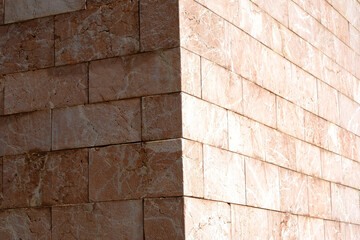 Geometric stone wall exterior with sunlit corner shadows
