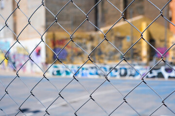 Urban playground: chain link fence and graffiti in city skatepark