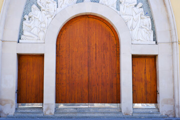 Architectural detail: intricate carving above large wooden church doors