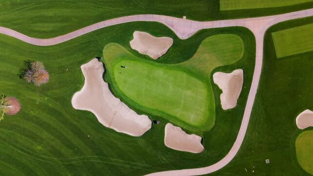 Golfers Practicing Putting on Scenic Green Course from Above