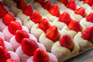 Rows of Daifuku - strawberry mochi, showcasing vibrant red strawberries nestled in soft, pale rice cakes. Two mochi variations are visible.