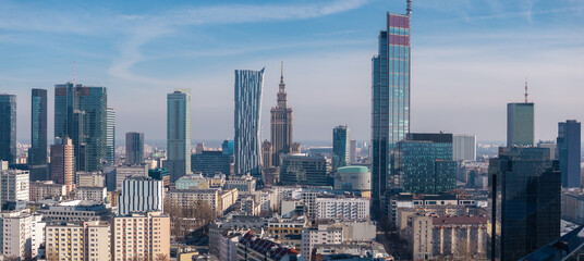 Naklejka premium Modern cityscape of Warsaw, Poland, featuring the Palace of Culture and Science, Zlota 44 tower, and a mix of historic and contemporary buildings.