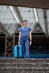 Fototapeta premium Young tourist standing at the top of stairs with suitcase at National Auditorium of Mexico City