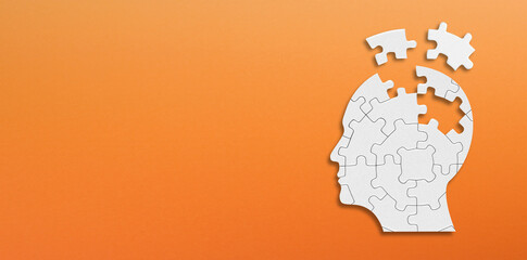 Head and brain diseases concept. A missing pieces of the brain puzzle on orange background. © ytemha34