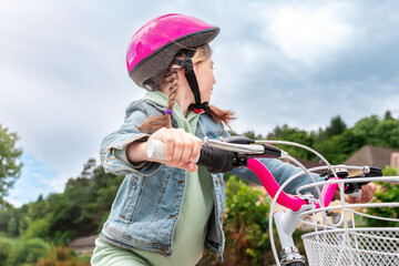 Obraz premium Cheerful child girl riding a bike