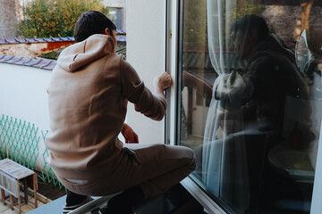 One person washes a window frame with a rag on the second floor.