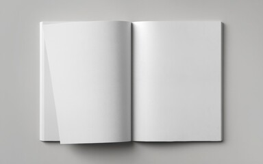 Naklejka premium An open blank book on a gray surface, showcasing two empty pages with one page partially turned.