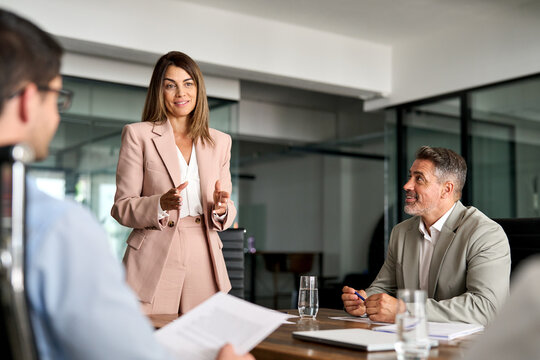 Busy mature professional board executive colleagues successful business team people collaborating having corporate teamwork discussion together at group office conference meeting boardroom table.